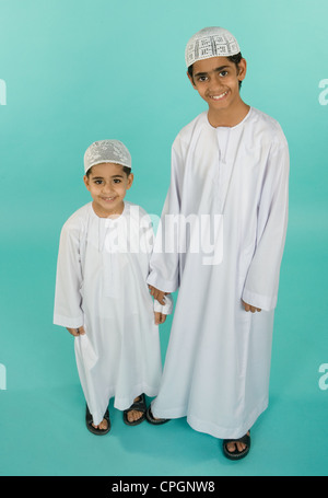 Fratelli indossando abiti tradizionali, ritratto, sorridente Foto Stock