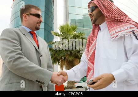Imprenditori stringono le mani, sorridente Foto Stock