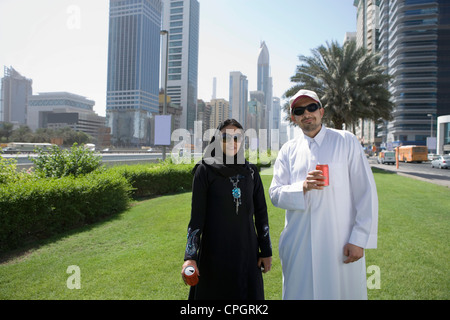 Coppia giovane in piedi con soft drink stagno Foto Stock