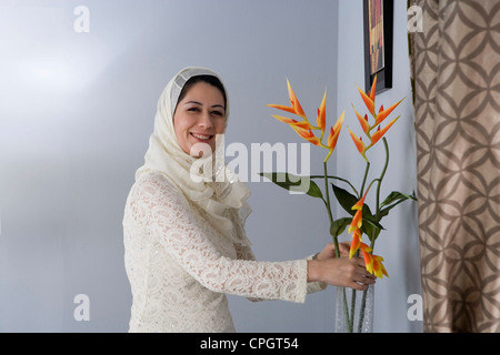 La donna araba disponendo dei fiori in un vaso Foto Stock