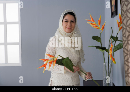 La donna araba disponendo dei fiori in un vaso Foto Stock