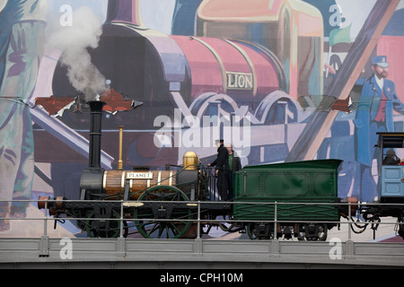 Replica del pianeta treno a vapore presso il Museo della Scienza e dell'Industria di Manchester REGNO UNITO passando grande murale di Lion Foto Stock