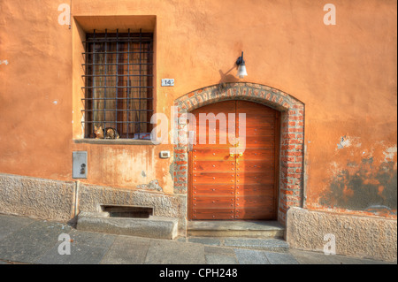 Porta in legno e vetro con barre su strada stretta nella città di Saluzzo, Italia settentrionale. Foto Stock