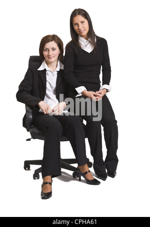Due giovani imprenditrici colleghi seduti su una sedia contro uno sfondo bianco. Foto Stock