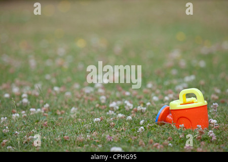 Childs red annaffiatoio sinistra sull'erba Foto Stock