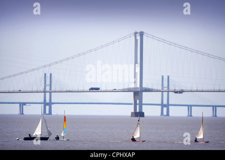 Velisti a una regata sul fiume Severn Estuary con il primo Severn Bridge più vicina e seconda Severn crossing in distanza Foto Stock