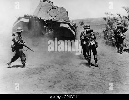 La fanteria tedesca avanza al di sotto dello schermo di un serbatoio, 1944 Foto Stock