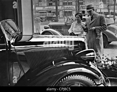 Un giovane guarda un Opel Super 6 in una concessionaria auto, 1935 Foto Stock