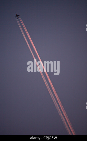 Un aereo di passeggero lasciando scie di condensazione nel cielo di sera, Belloe, Svezia Foto Stock