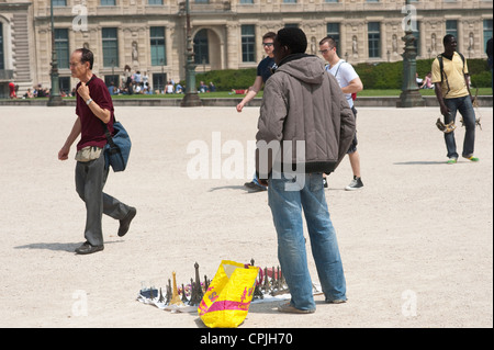 Parigi Francia - un fornitore africani cercando di vendere souvenir ai turisti. Foto Stock