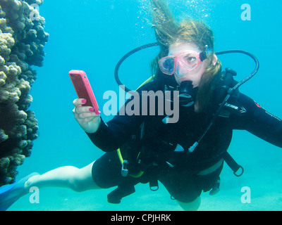 SCUBA DIVER utilizza lo smartphone (Iphone) sott'acqua Foto Stock