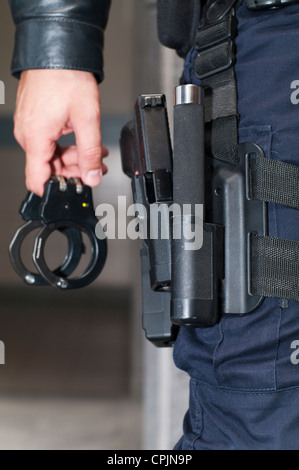 La polizia portoghese (PSP) forze di uomini con bracciali a mano, di una pistola e accessori Foto Stock