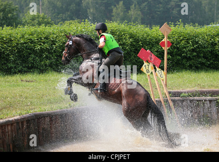 Cavaliere a cavallo salta un ostacolo di acqua durante una tre giorni di gestione degli eventi Foto Stock