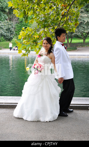 Una giovane coppia asiatica rappresentano per loro foto di nozze nei pressi di un laghetto di Central Park di New York City Foto Stock