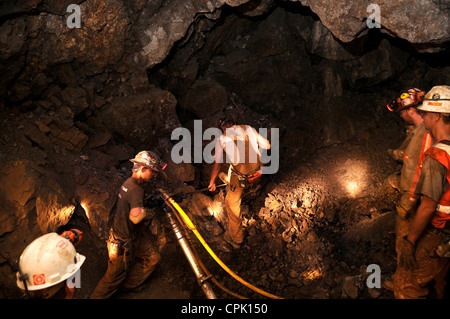 Ingegneria mineraria agli studenti di praticare i fori per la sabbiatura in polvere in una miniera sotterranea. Foto Stock