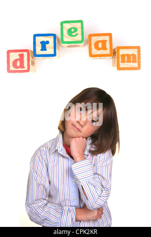 Una giovane ragazza in una postura di sognare con la parola sogno sopra in blocchi. Foto Stock