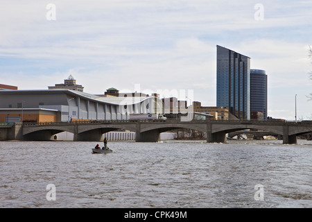Due persone di pesca in barca sul grande fiume con il centro di Grand Rapids in background Foto Stock