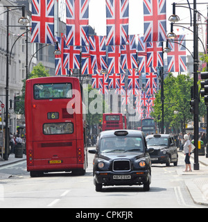 Gli autobus di colore rosso e nero taxi a Oxford Street con il giubileo Unione martinetti che possono anche essere nel luogo durante il 2012 Olimpiadi Foto Stock