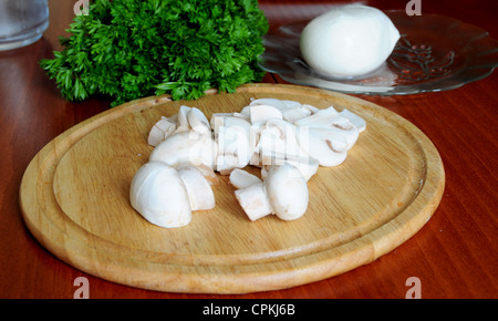 I funghi tritati sul tagliere in legno con prezzemolo e mozzarella Foto Stock