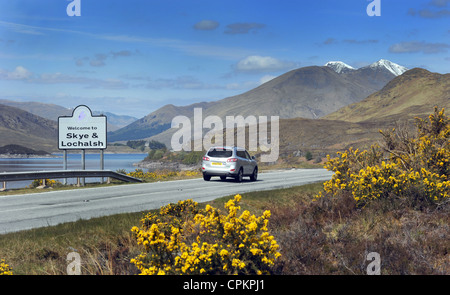 Una vettura viaggia passato un cartello stradale accoglie i visitatori a Skye e LOCHALSH sulla A87 IN SCOZIA RE MOTORING TOURING Vacanze REGNO UNITO Foto Stock