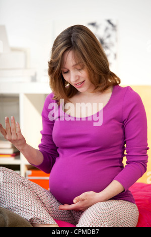 Donna incinta in ambienti interni Foto Stock