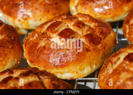 Appena sfornato il formaggio e pancetta affumicata pogacsas (ungherese scones salati) raffreddare su una griglia. Foto Stock