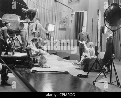 Joan Crawford, Harry Beaumont, Robert Montgomery e Hedda tramoggia sul set, 1930 Foto Stock