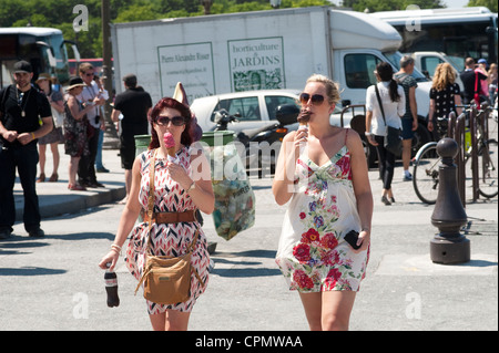Parigi, Francia - Due giovani donne a camminare e mangiare il gelato Foto Stock