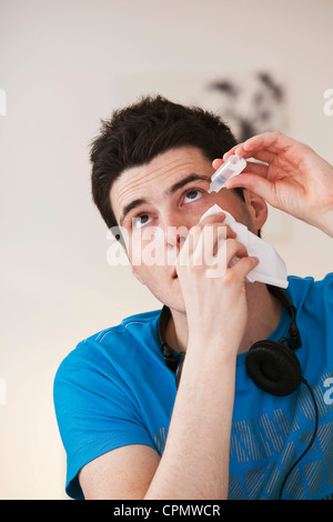 Adolescente usando lozione oculare Foto Stock