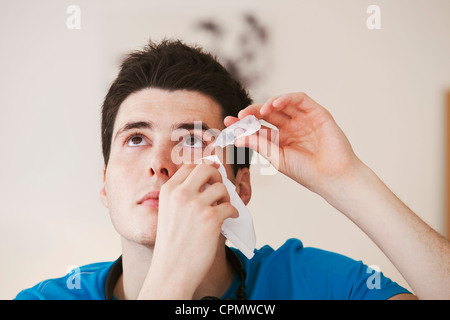 Adolescente usando lozione oculare Foto Stock