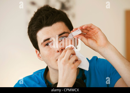 Adolescente usando lozione oculare Foto Stock