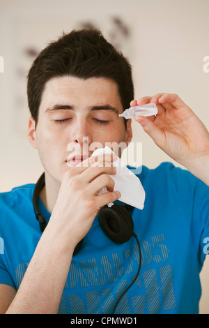 Adolescente usando lozione oculare Foto Stock