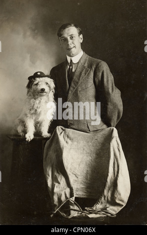 Uomo con carino piccolo cane bianco che indossa un cappello Foto Stock