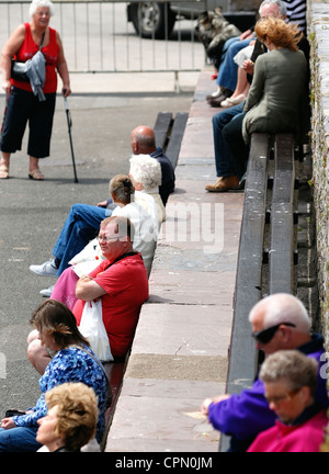 Brixham Devon England Regno Unito vacanzieri seduti sui banchi Foto Stock