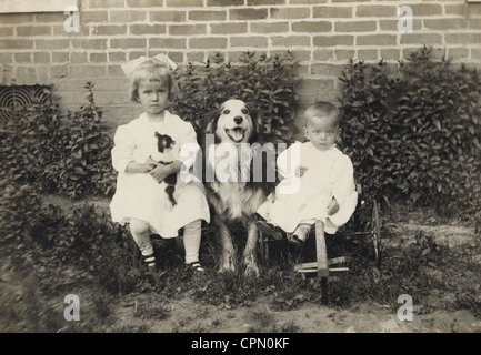 Due bambini piccoli con cane grande tra di loro Foto Stock