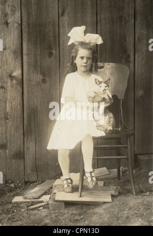 Bambina con grandi capelli Bow che stringe la Cat Foto Stock