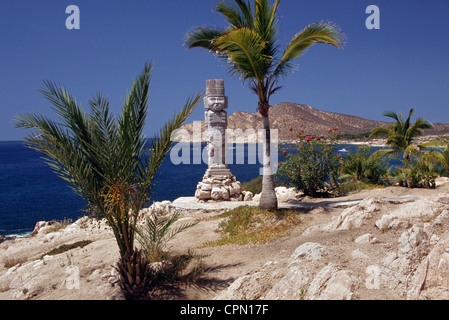 Un lone stone Aztec statua si trova in corrispondenza del bordo del mare di Cortez nel villaggio turistico città di Cabo San Lucas sulla penisola della Baja California in Messico. Foto Stock