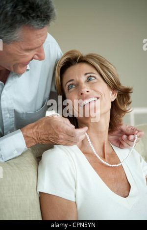 Uomo maturo dando donna una collana di perle Foto Stock