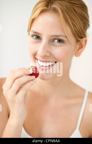 Giovane donna di mangiare fragole, ritratto Foto Stock