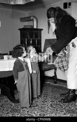 Natale, San Nicola visitando due bambini, Germania, dicembre, 1953, attenzione! Non deve essere usato nel contesto negativo Foto Stock