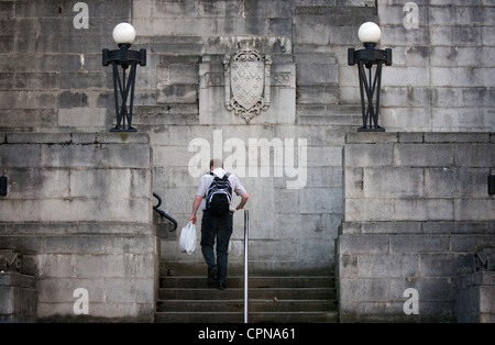 Un uomo salire a piedi a Stockport centro storico concreto Plaza passi Foto Stock