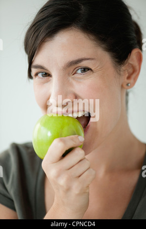 Metà donna adulta di mordere in apple Foto Stock