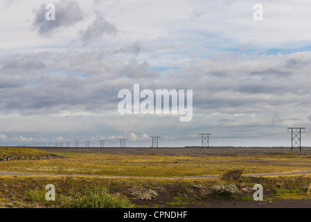 Le linee di alimentazione che corre attraverso il campo rurale Foto Stock