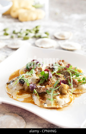 Ravioli con stufare Stinco di vitello,i carciofi e funghi saltati Foto Stock