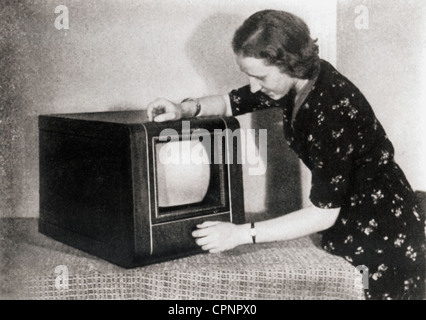 Trasmissione,televisione,donna con televisore Set Telefunken tavolo TF 1,con cinescopio da 25 centimetri,uno dei primi televisori da tavolo,stampa foto del produttore,Germania,1938,cinescopio rotondo,televisore,TV,televisori,TV,storia TV,storia multimediale,manipolazione,uso,30s,invenzione,invenzioni,unità da tavolo,unità da tavolo,compatto,televisore,tubi di intrattenimento domestico,altri,canali,televisione-canali di intrattenimento,programmi elettronici,non-TV-TV-TV-TV-TV-TV-TV-TV-TV-TV-TV-canali disponibili,canali di intrattenimento,canali di intrattenimento-TV-TV-TV-TV-TV-TV-TV-TV-TV-TV-TV-TV- Foto Stock