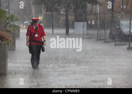 Il traffico di Manchester operaio lavorando sotto la pioggia Foto Stock