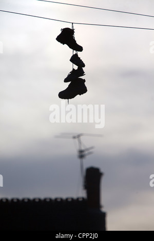 Scarpe mano dalla linea telefonica in una strada di Salford Foto Stock