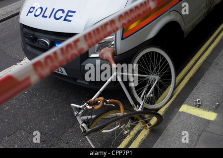 Una bicicletta mangled appoggia contro una polizia metropolitana van dopo un apparentemente grave incidente nel trefolo. Foto Stock