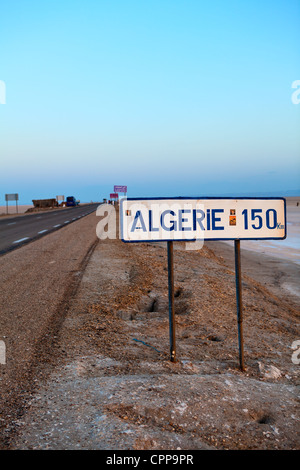 La strada attraverso il lago salato Chott el Djerid dalla Tunisia in Algeria nelle prime ore del mattino Foto Stock