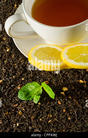 White tazza di tè accanto a una foglia verde Foto Stock